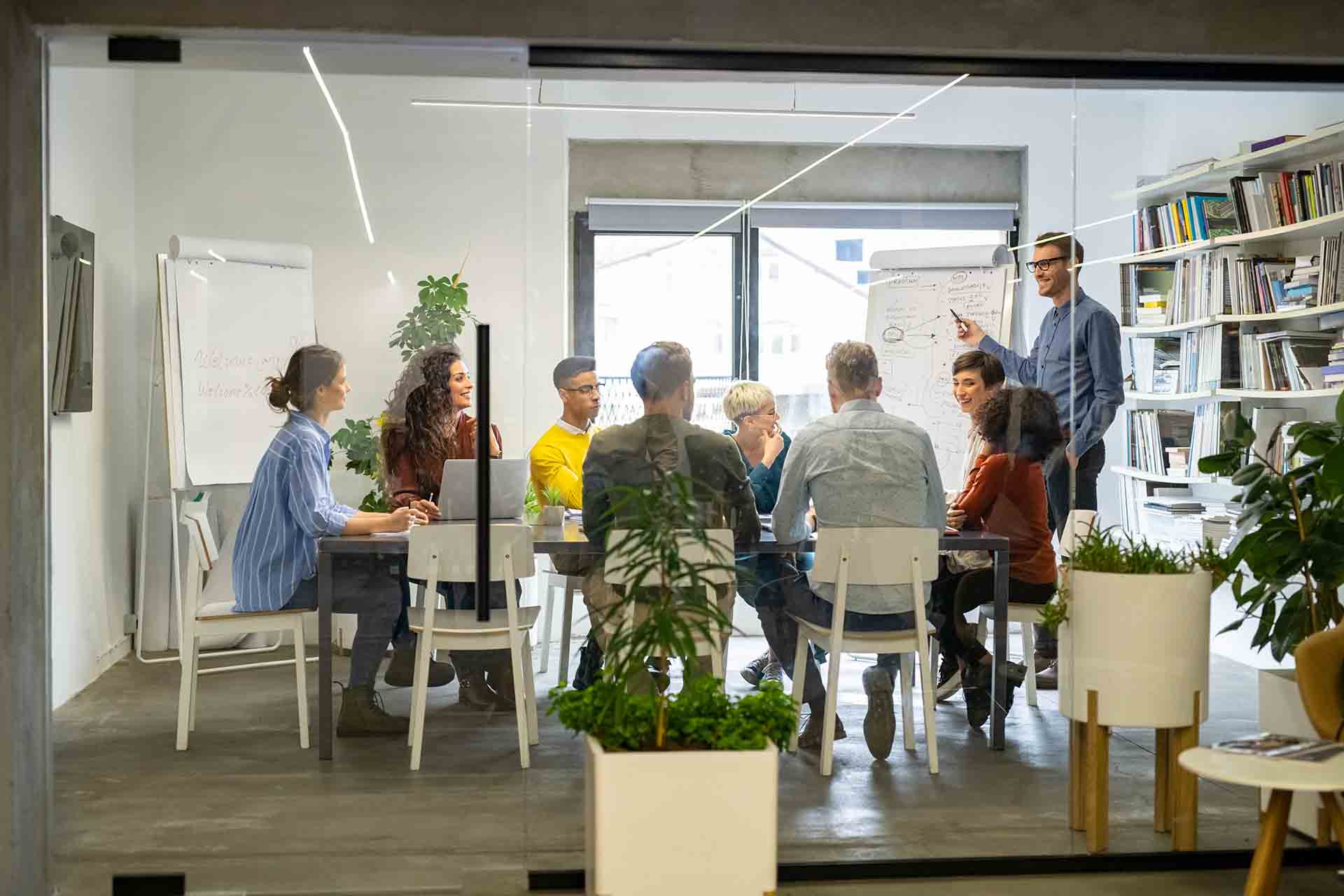 Man leading a group meeting in a glass conference room